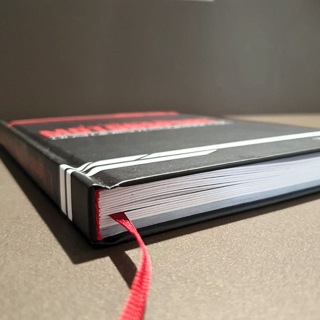 Dettaglio della copertina rigida nera dell'Agenda con il segnalibro in nastro rosso