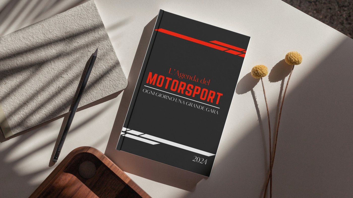 L'Agenda del Motorsport di un'edizione precedente appoggiata su una scrivania bianca, accanto a un taccuino e a una matita